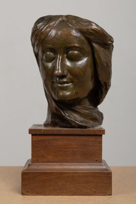 sculpture of a woman ' s head on a wooden base