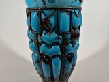 a blue glass vase with a black design on it