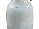 a white vase that is sitting on a stand