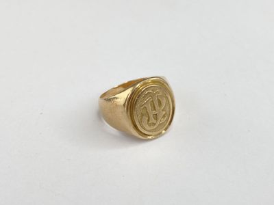 a close up of a gold ring with a monogram on it