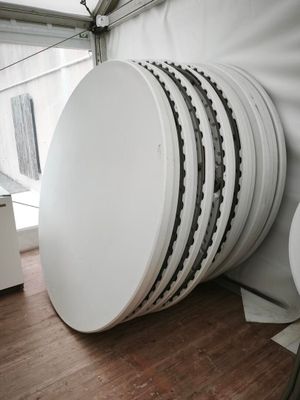 plusieurs assiettes blanches empilées les unes sur les autres sur un plancher en bois