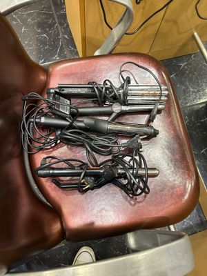 une chaise marron sur laquelle sont posés tout un tas d'appareils de coiffure