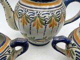 a tea pot and two cups sitting on a table