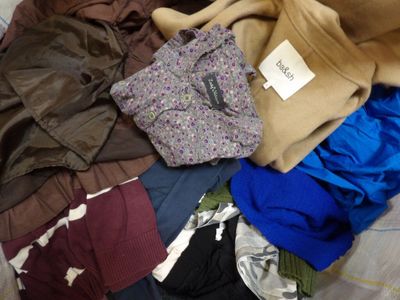 un tas de vêtements sur un lit, avec une étiquette dessus