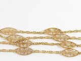 a close up of a gold chain bracelet with leaves on it
