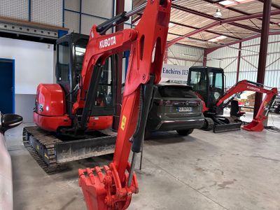 une pelleteuse rouge garée à l'intérieur d'un bâtiment