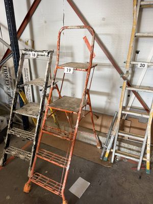 de nombreuses échelles entreposées dans un garage