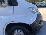 a white van parked in a parking lot with other cars in the background