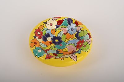 une assiette jaune ornée d'un motif floral coloré