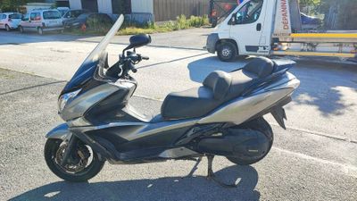 a silver and black scooter parked on the side of the road