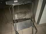 une chaise en métal posée devant un poêle