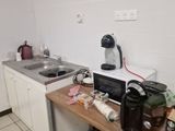 a small kitchen with a sink and a coffee maker on the counter