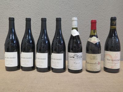 plusieurs bouteilles de vin alignées sur une table devant un mur