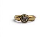 a close up of a gold ring with a white diamond