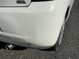 a close up of a white car parked on the side of the road