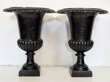 two black vases sitting on top of a white table