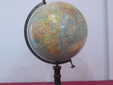 a small globe on a stand on a red table