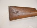 a close up of a wooden rifle on a white surface
