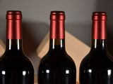 three bottles of red wine sitting on a table