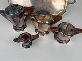 a silver tray with silver teapots and a tray with silver teapots on it