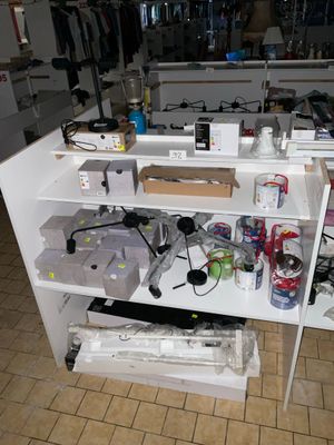une étagère blanche sur laquelle sont posés de nombreux objets, dans la cuisine