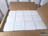 a cardboard box filled with white tiles on the floor