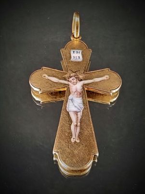 une croix en or surmontée d'un crucifix