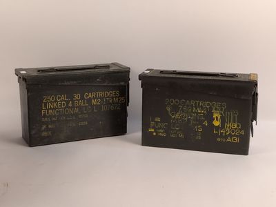 deux vieilles boîtes de munitions militaires posées côte à côte sur une surface blanche