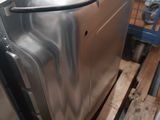 stainless steel dishwasher sitting on a pallet in a kitchen
