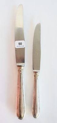 deux couteaux posés l'un à côté de l'autre sur une table