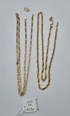 trois colliers à chaînes en or et une étiquette posés sur une surface blanche