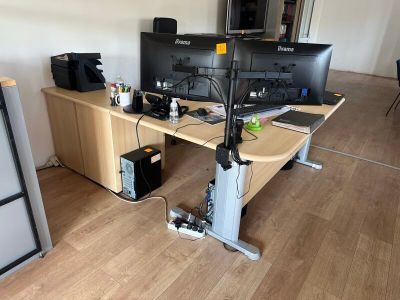 a desk with two computer monitors and a printer on it