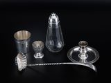 an assortment of silver and glass items on a black surface