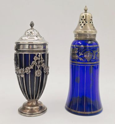 une paire de salières et poivrières en verre bleu sur fond blanc