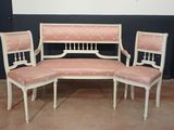 trois chaises et un banc dans une pièce aux murs noirs