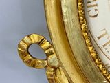 a gold clock with roman numerals on the face of it