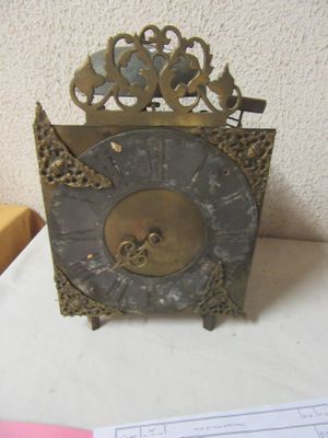 a clock that is sitting on a table next to a piece of paper