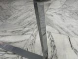 a glass table with a metal base on a marble floor