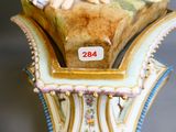 une figurine représentant une femme assise sur un vase