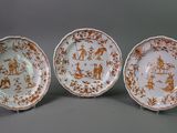 three plates with brown and white designs on them on a gray surface
