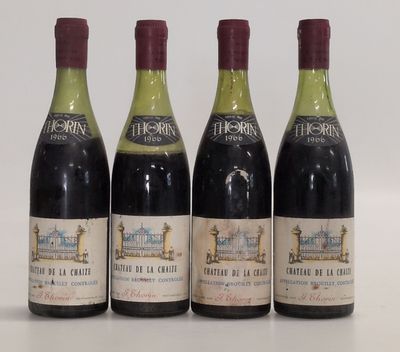quatre bouteilles de vin sont alignées sur une surface blanche
