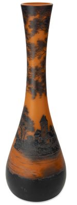 un vase noir et orange posé sur une surface blanche