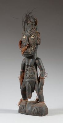 une statue en bois représentant un homme à la grosse tête