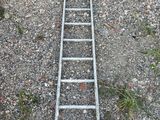a ladder that is laying on the ground next to a car