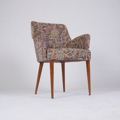 une chaise rembourrée avec une assise rembourrée à motifs et des pieds en bois