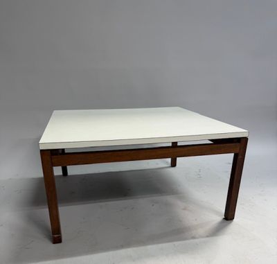 une table basse blanche avec un piètement en bois et un plateau blanc