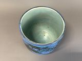 a close up of a blue and white cup on a table