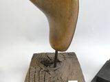 une sculpture en bois représentant un oiseau, posée sur un socle en bois