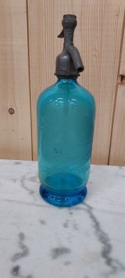 a blue glass bottle sitting on a marble counter top