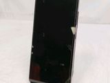 the back of a black cell phone sitting on top of a white table